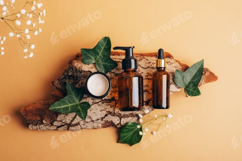 Preview: Bottle of cosmetic serum, facial cleanser and cream in a jar on tree bark with green leaves. Spa