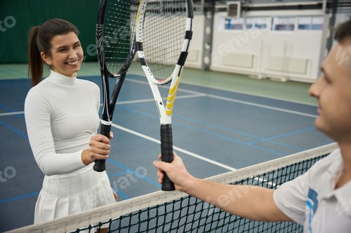 Preview: Smiling tennis players man and woman with rocket