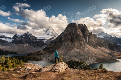 Preview: Women traveler standing on cliff with Mount Assiniboine on Niblet in provincial park