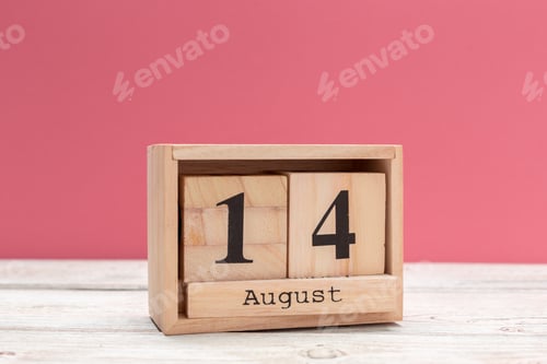 Vista previa: wooden cube shape calendar for august 14 on wooden tabletop