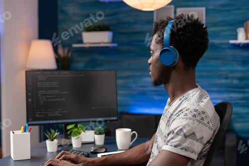 Preview: African american young programmer wearing headphone