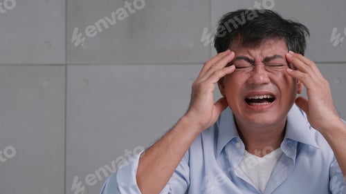 Preview: Asian old man with migraine headache. Man feel stressed and worried about health problems.