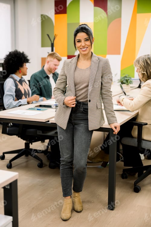 Preview: Confident businesswoman smiling in modern office with diverse colleagues