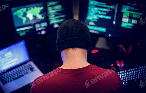 Preview: Rear view of man working on computer coding program