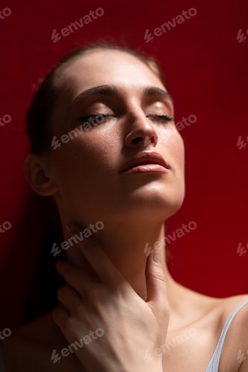 Preview: True sensuality. Charming young brunette woman posing near red wall