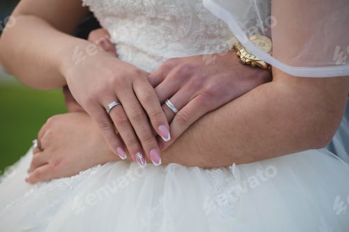 Preview: Closeup of a bride and groom holding hands