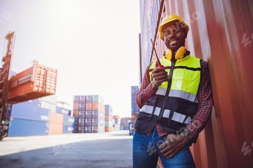 Preview: Portrait staff worker happy smile working in cargo shipping logistic port hand holding radio control