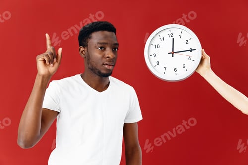 Preview: man of african appearance next to the clock time emotions red background