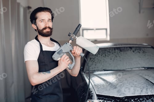 Preview: Man washing his car in a garage