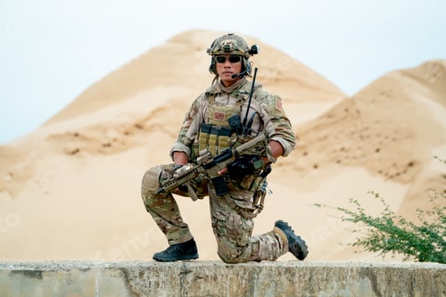 Preview: Soldier or military man sit with guarded position and look at camera in area look like desert