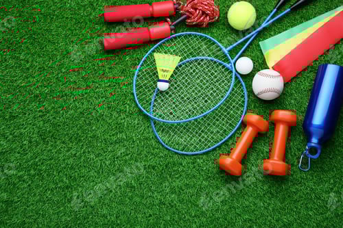 Preview: Set of different colorful sports equipment on green grass, flat lay. Space for text