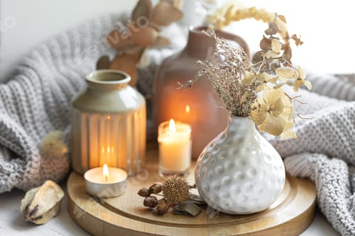 Preview: A cozy composition with candles, dried flowers in a vase and a knitted element.