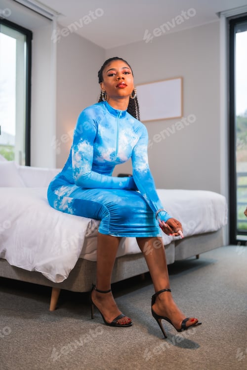 Preview: Fashion lifestyle of a black ethnic girl with collected hair and a blue dress