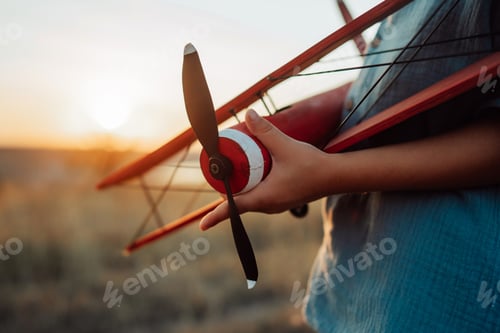 Preview: Close-up hands of child Boy holds Craft Wooden Retro Styled Airplane. Traveling