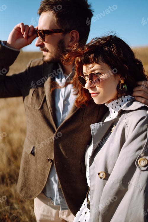 Preview: Stylish and loving couple enjoying each other outdoors. Stylish couple walking and hugging.
