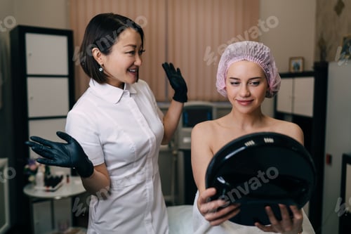 Preview: Women looking at mirror after botox injection