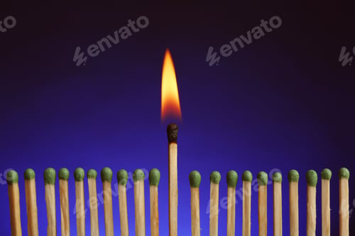 Preview: Burning match among others on color background. Difference and uniqueness concept