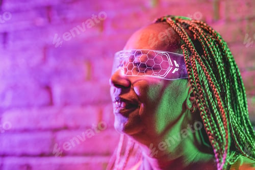 Preview: African senior woman wearing virtual reality glasses indoor