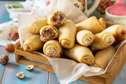 Preview: Homemade pastries. Crispy cookies with nut filling on a wooden table.