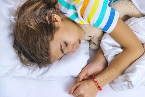 Preview: The child sleeps in the morning in bed. Selective focus.