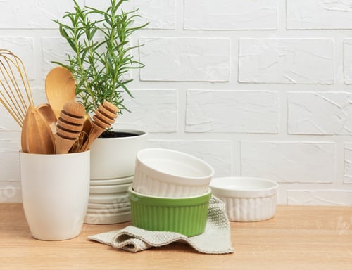 Preview: Kitchen utensils, rosemary plant, and ramekins creating a cozy culinary scene