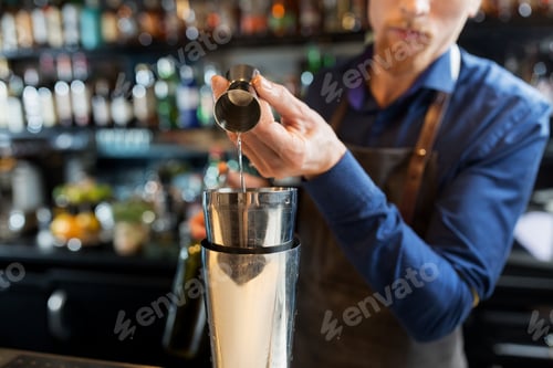 Preview: barman with shaker preparing cocktail at bar