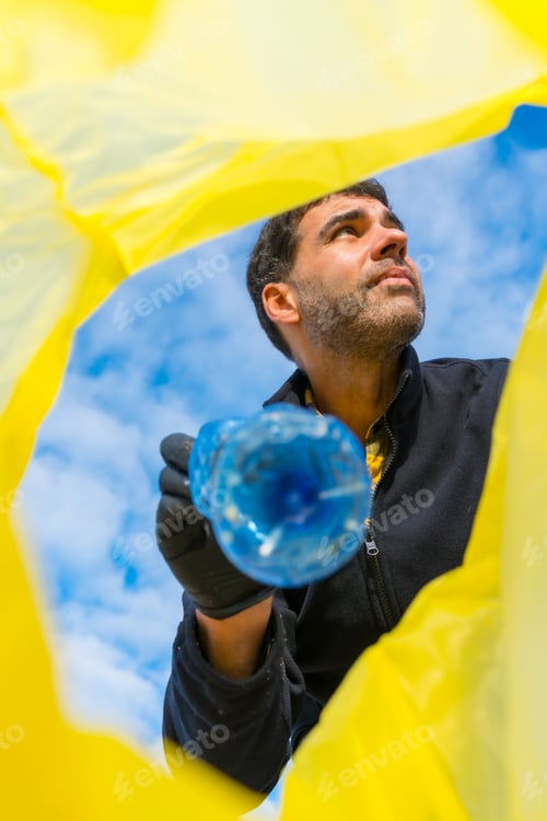 Preview: Portrait of man picking up trash the beach. Ecology, sea pollution, cleaning the sand from plastics