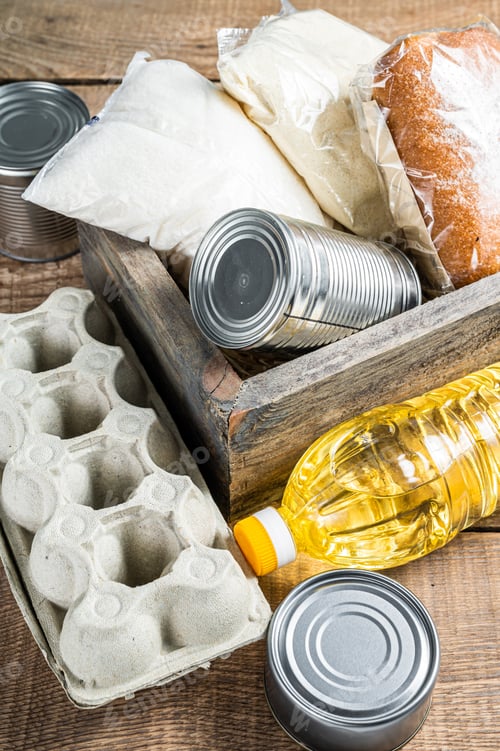 Vista previa: Wooden box with Donation food, quarantine help concept. Oil, canned food, pasta, bread, sugar, egg
