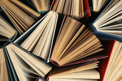 Preview: Many different hardcover books on dark background, top view