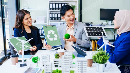 Preview: Trio of businesspeople, including a middle-aged Asian man and woman, strategize at their desk