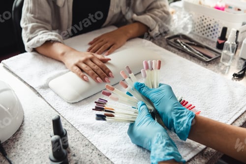Preview: Choose of trendy color in beauty studio. African american woman in protective gloves showing samples