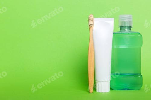 Preview: Mouthwash and other oral hygiene products on colored table top view with copy space.