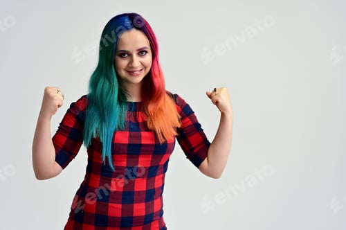 Preview: Portrait Of A Pretty Girl With Multi-Colored Hair And Make-Up On A White Background. Stands With A