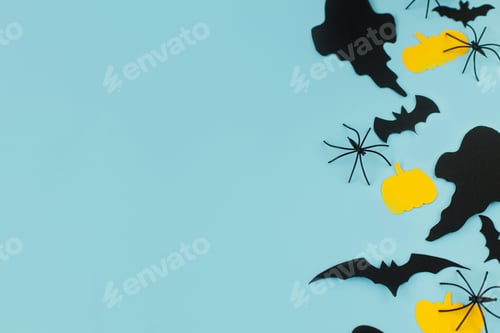 Preview: Halloween. Black ghosts, spiders, bats and yellow pumpkins decorations on blue background flat lay