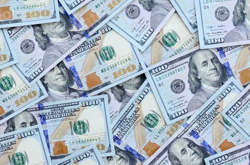 Preview: A large number of US dollar bills of a new design with a blue stripe in the middle. Top view.
