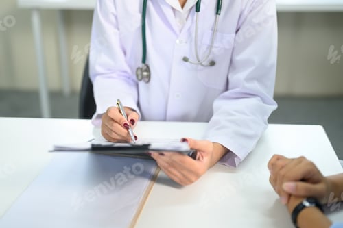 Preview: Close up of doctor writing notes on a clipboard during patient consultation