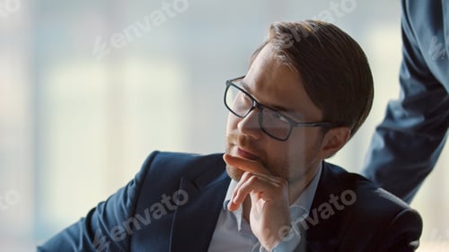 Preview: Financial analysts in suits discussing new project with colleagues