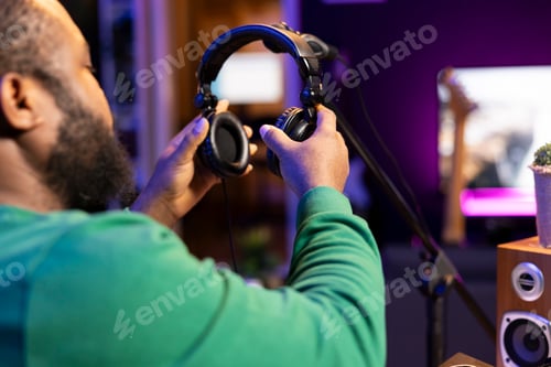 Preview: Trained audio technician picking up his headset for a recording session