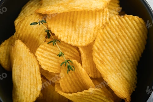 Preview: Potato chips. Fast food. Crispy potato chips ceramic black bowl with sour cream sauce and onions in