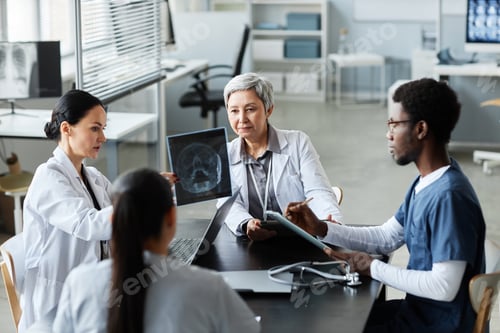 Preview: Group of intercultural radiologists discussing scalp x-ray results of patient