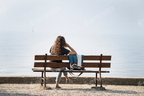 Preview: Rear view of woman sitting on bench looking at Lake Garda, Torri del Benaco, Veneto, Italy, Europe