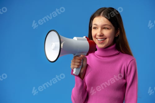 Preview: Teen girl making announcement with megaphone on blue background