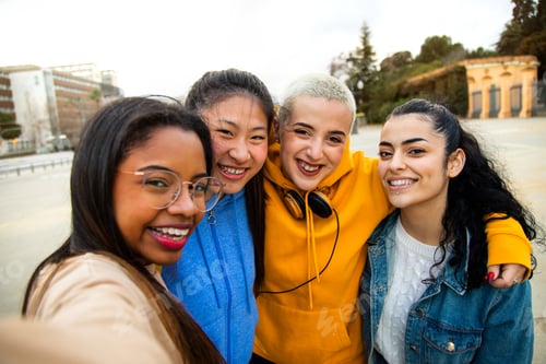 Preview: Happy multiracial female teen college student friends take selfie and have fun together outdoors.