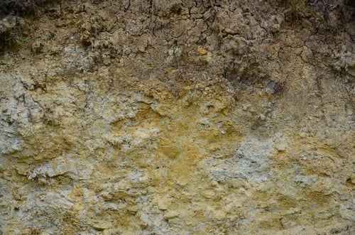 Preview: Texture of a wall of solid yellow and brown sand in a sandy quarry