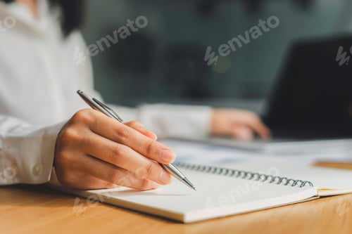 Preview: Business women hand And notepads placed on the table in the office, writing ideas And taking notes
