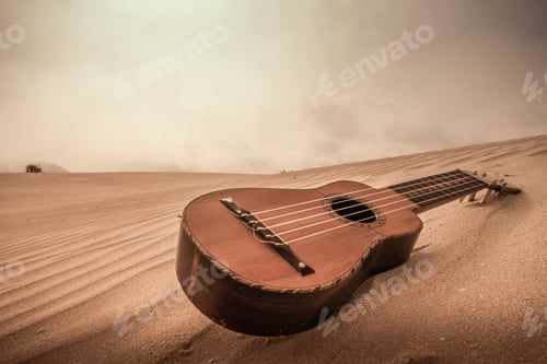 Preview: Closeup shot of the guitar on the sand in a desert