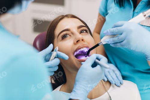 Preview: Dentists give the girl ultraviolet teeth whitening in a dental clinic