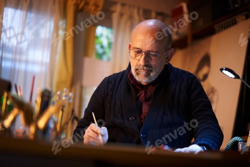 Preview: artist working in studio. Middle-aged man making creative artwork