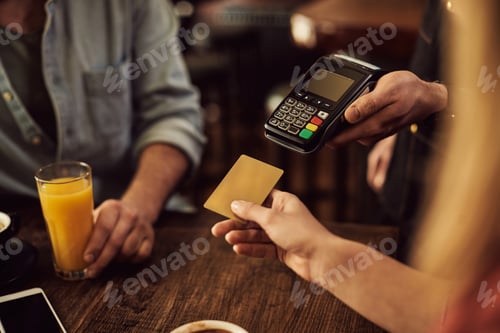 Preview: Close-up of woman paying with credit card in a cafe.