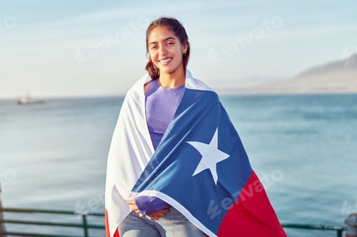 Preview: chilean woman holding over the shoulders a flag of Chile outdoors